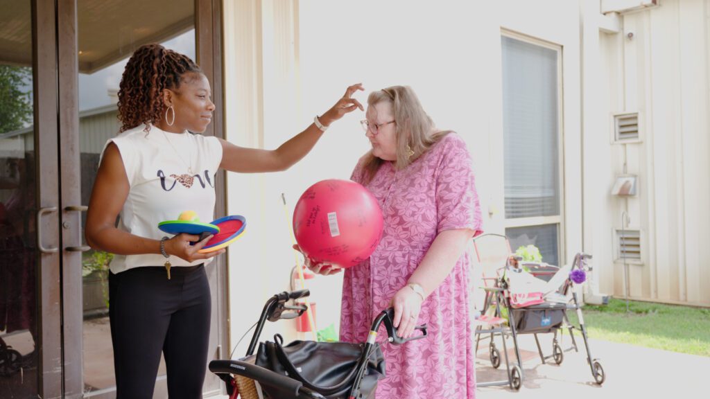 A nurse plays a game with a long-term care resident at a skilled nursing facility